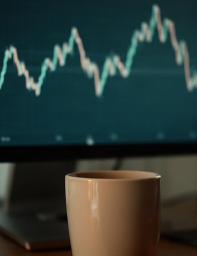 値動きの線を表示した画面と静かに置かれたコーヒーカップ